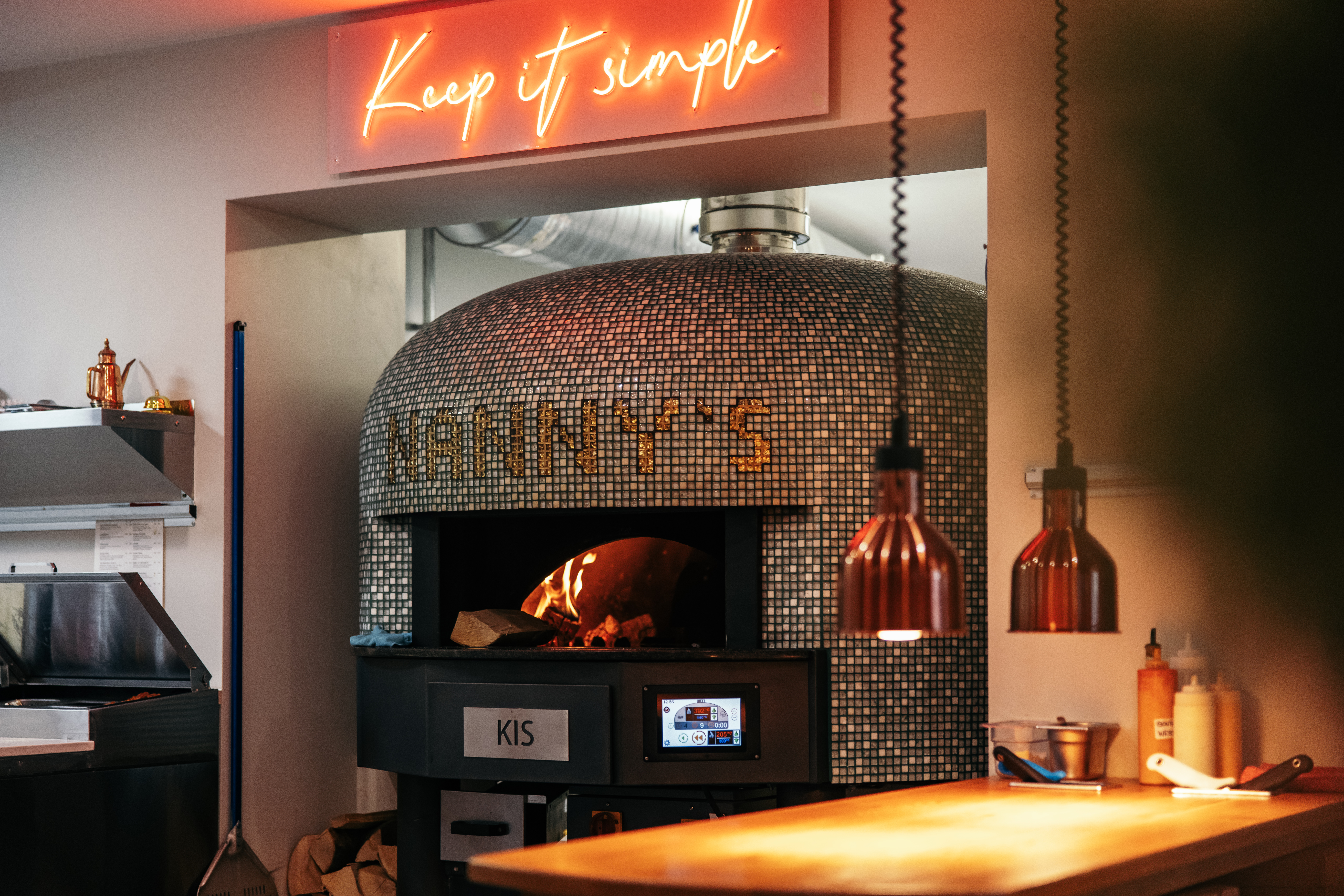 Pizza oven with a sign that says 'Keep It Simple' above it.
